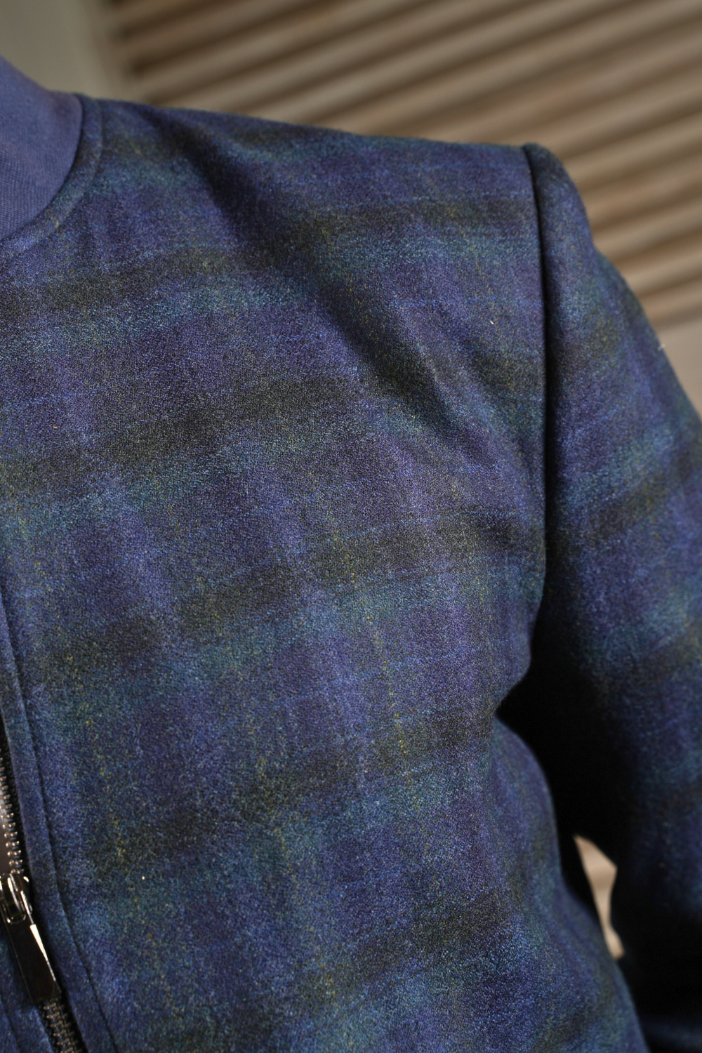 Close-up of a blue and green plaid fabric with a zipper.